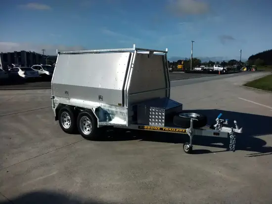 White tandem axle enclosed trailer with aluminium canopy sides and front toolbox compartment.