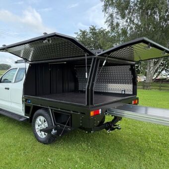 Heavy duty black utility canopy with dual gullwing side access and slide out tray system built by Gibbons Engineering.
