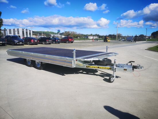 Tandem axle galvanised flat deck trailer with drop sides parked outside Gibbons Engineering.