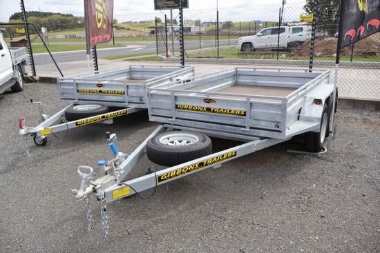 Two galvanised Gibbons Trailers parked side by side on a gravel yard.