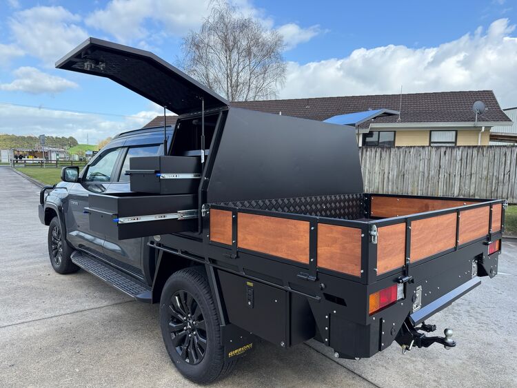 Custom black utility tray with canopy storage compartments and timber side panels built by Gibbons Engineering.