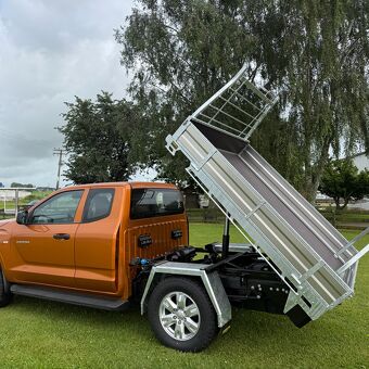 Hydraulic tipping ute tray fitted to an orange pickup truck for heavy duty transport and unloading applications by Gibbons Engineering.