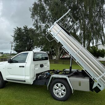 White pickup truck fitted with a hydraulic tipping tray designed and manufactured by Gibbons Engineering for commercial use.