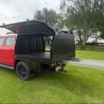 Custom black canopy tray with slide out rear drawer system manufactured by Gibbons Engineering for practical storage access.