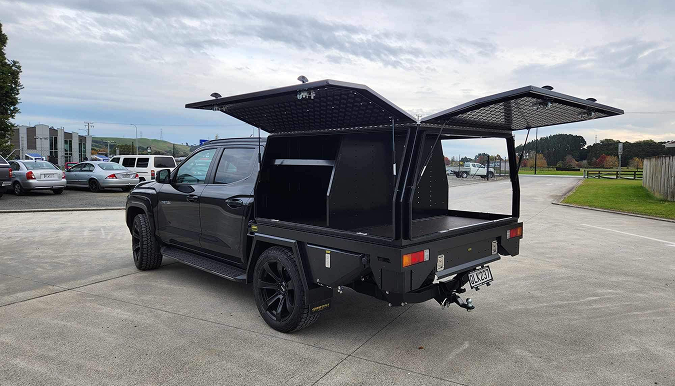 Custom utility vehicle tray with lift-up storage compartments designed and manufactured by Gibbons Engineering.