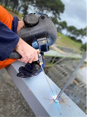 Close up of a welder joining steel sections during a fabrication project at Gibbons Engineering.